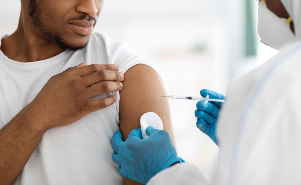 A man receiving an immunization in his arm at a family medicine clinic in El Paso.